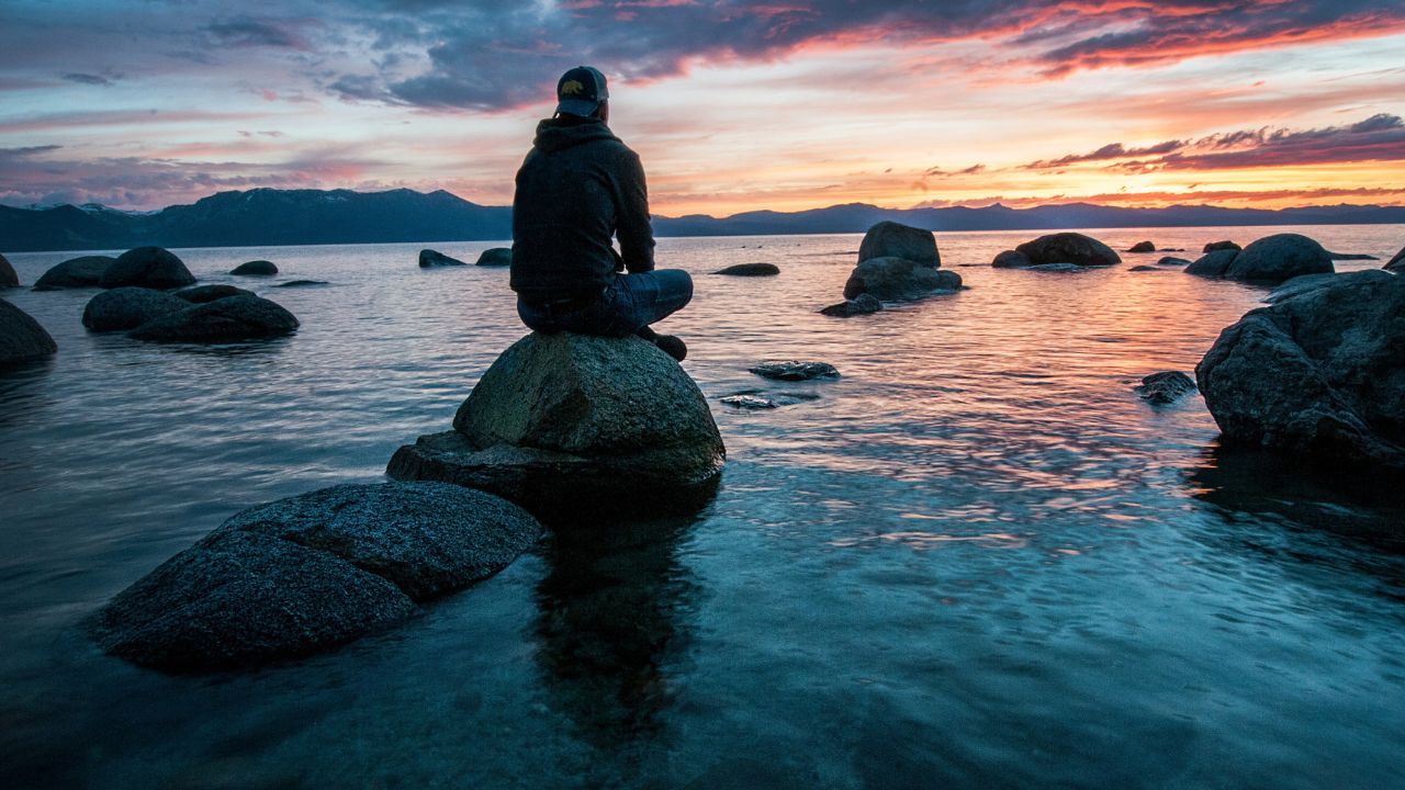 Escape Financial Stress 7 Keys to Inner Peace with Money - Secured Profits (on photo: man sitting on stone)